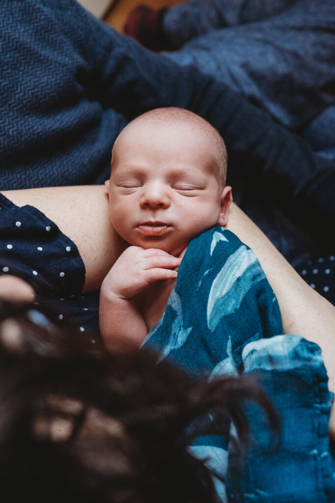 at home newborn photoshoot of baby boy with mom and dad wearing complimenting blues